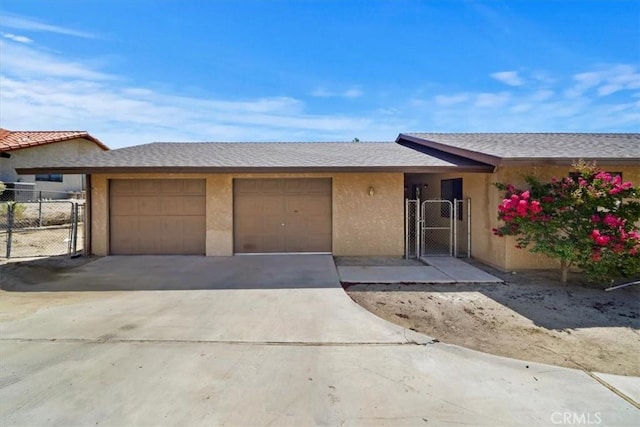 7575 Whitney Ave, Yucca Valley, CA 92284 - ranch-style home with an attached garage, driveway, stucco siding, and a gate