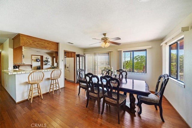 7575 Whitney Ave, Yucca Valley, CA 92284 - dining room with dark wood-style flooring, a ceiling fan, and a textured ceiling