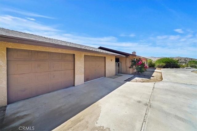 7575 Whitney Ave, Yucca Valley, CA 92284 - view of front facade with a garage, concrete driveway, and stucco siding
