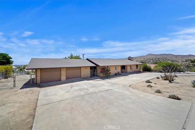 7575 Whitney Ave, Yucca Valley, CA 92284 - ranch-style home with concrete driveway, a garage, and a mountain view