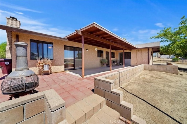 7575 Whitney Ave, Yucca Valley, CA 92284 - rear view of property with a patio, a chimney, and stucco siding
