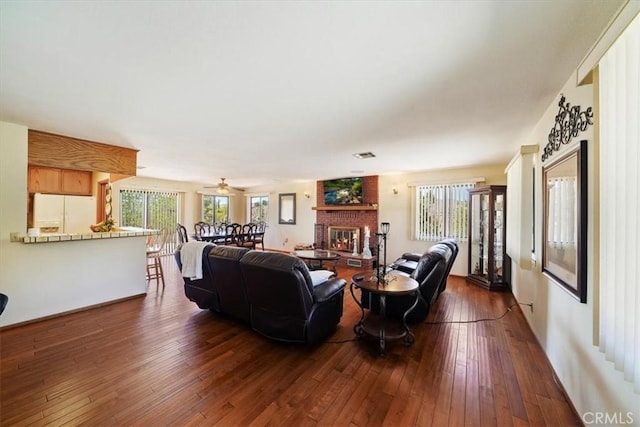 7575 Whitney Ave, Yucca Valley, CA 92284 - living area with healthy amount of natural light, dark wood-style floors, and a brick fireplace