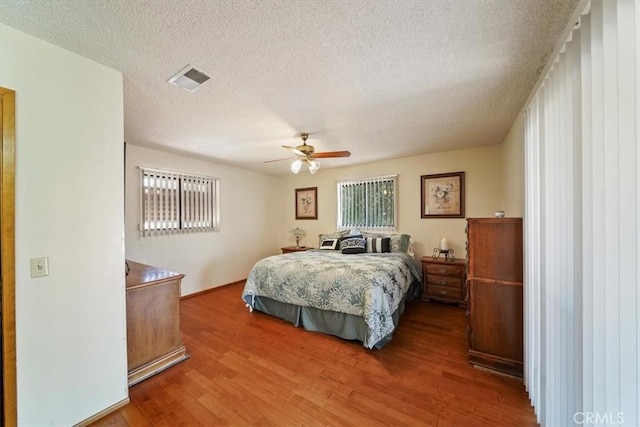 7575 Whitney Ave, Yucca Valley, CA 92284 - bedroom featuring wood finished floors, a textured ceiling, and a ceiling fan