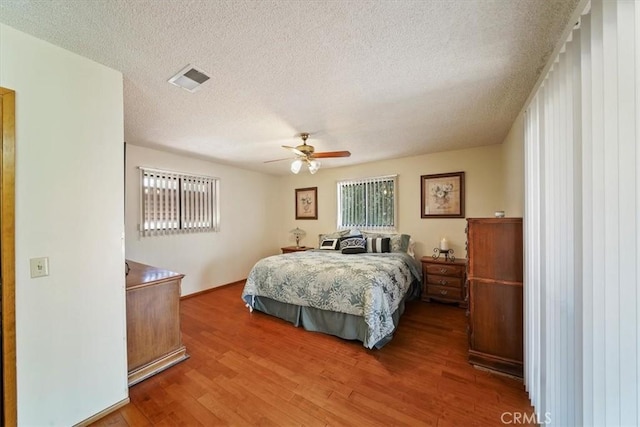 7575 Whitney Ave, Yucca Valley, CA 92284 - bedroom featuring wood finished floors, a textured ceiling, and a ceiling fan