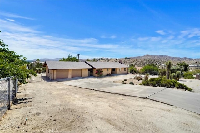 7575 Whitney Ave, Yucca Valley, CA 92284 - ranch-style house with a garage, concrete driveway, and a mountain view