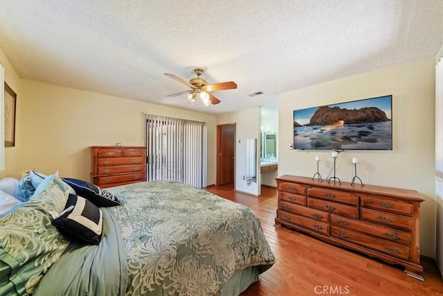 7575 Whitney Ave, Yucca Valley, CA 92284 - bedroom featuring wood finished floors, a textured ceiling, ceiling fan, and connected bathroom