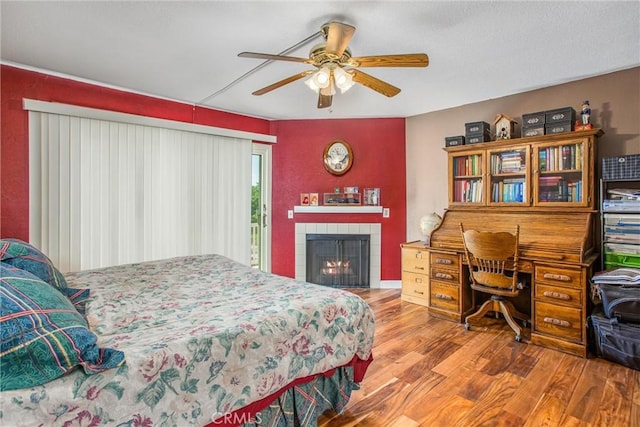 10735 Juniper Ave, Fontana, CA 92337 - bedroom with wood finished floors, access to exterior, a tiled fireplace, and ceiling fan