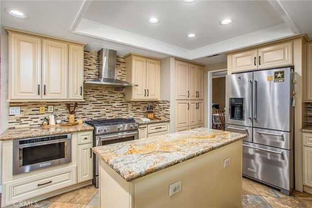 10735 Juniper Ave, Fontana, CA 92337 - kitchen featuring appliances with stainless steel finishes, wall chimney range hood, cream cabinetry, a kitchen island, and decorative backsplash