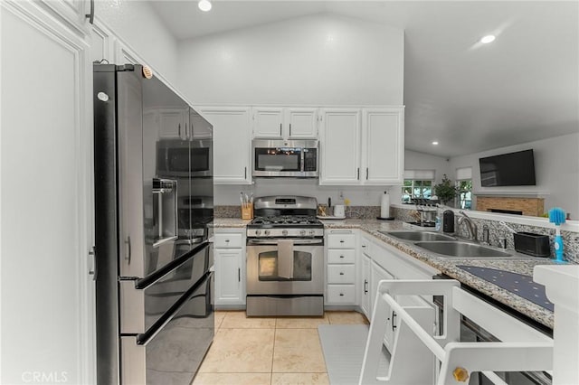 22792 Springdale Dr, Moreno Valley, CA 92557 - kitchen with appliances with stainless steel finishes, lofted ceiling, light tile patterned floors, white cabinetry, and recessed lighting