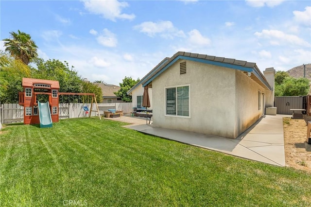 22792 Springdale Dr, Moreno Valley, CA 92557 - back of property with a fenced backyard, a patio area, a playground, and stucco siding