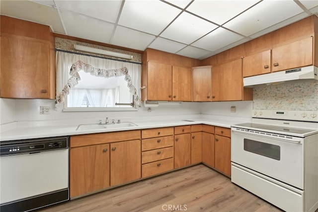 1181 Sandlewood Dr, Hemet, CA 92543 - kitchen with white appliances, under cabinet range hood, light countertops, light wood-type flooring, and a drop ceiling