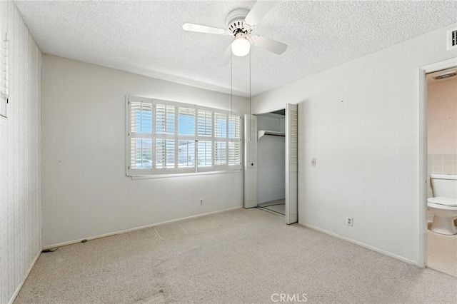 1181 Sandlewood Dr, Hemet, CA 92543 - unfurnished bedroom featuring a textured ceiling, carpet, connected bathroom, a ceiling fan, and a closet