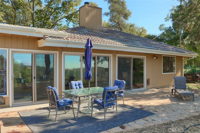 35484 Rd 274, North Fork, CA 93643 - rear view of house with a patio area, a tiled roof, outdoor dining area, and a chimney