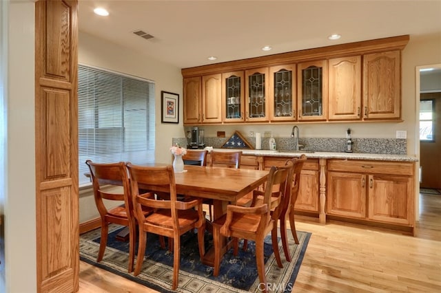 35484 Rd 274, North Fork, CA 93643 - kitchen featuring light wood-type flooring, glass insert cabinets, recessed lighting, and light stone countertops