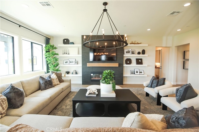 7051 Hurley Ct, San Bernardino, CA 92407 - living room featuring a chandelier, recessed lighting, built in shelves, a large fireplace, and wood finished floors