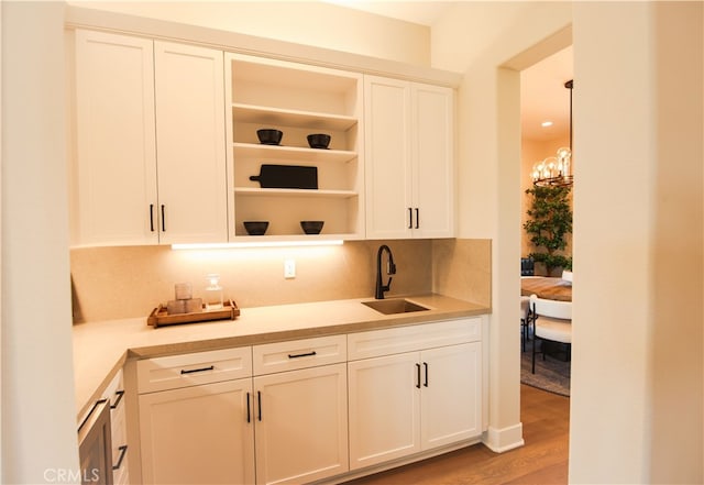 7051 Hurley Ct, San Bernardino, CA 92407 - bar with decorative backsplash, light wood-style flooring, and a chandelier