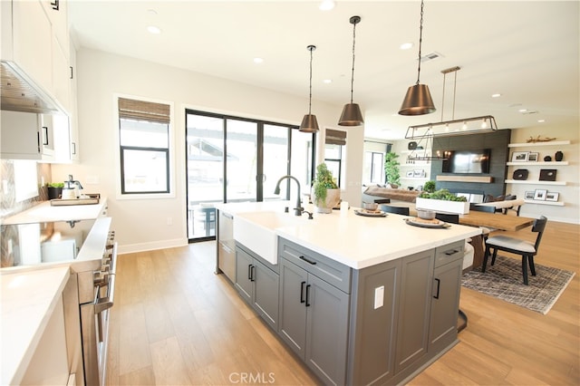 7051 Hurley Ct, San Bernardino, CA 92407 - kitchen with gray cabinets, light wood-style flooring, high end range, open floor plan, and recessed lighting