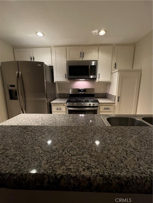 16040 Leffingwell Rd Unit 78, Whittier, CA 90603 - kitchen with appliances with stainless steel finishes, dark stone counters, white cabinets, and recessed lighting
