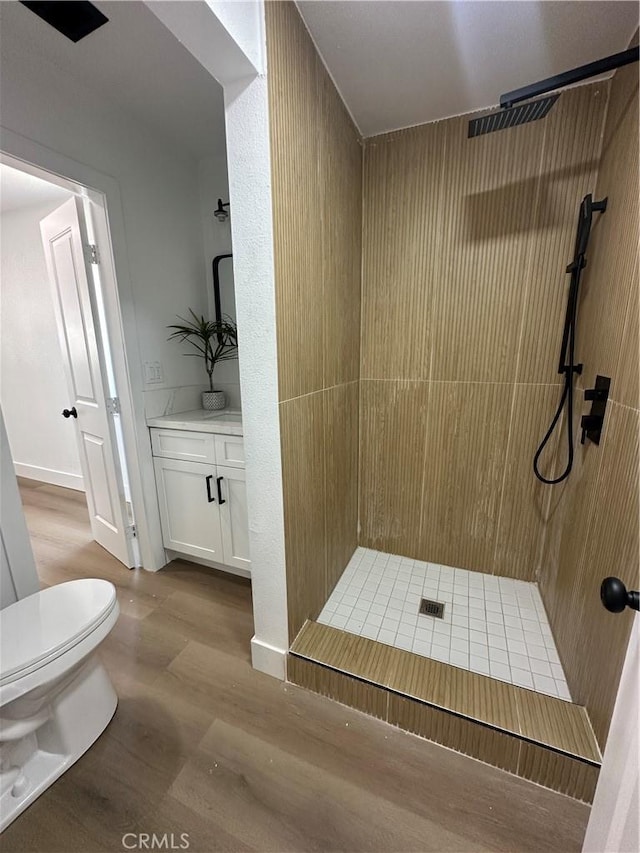 1598 W 7th St, San Bernardino, CA 92411 - bathroom featuring a tile shower, vanity, and wood finished floors