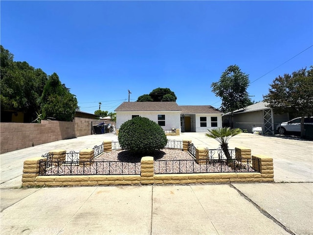 1598 W 7th St, San Bernardino, CA 92411 - view of front facade with a fenced front yard, concrete driveway, and stucco siding