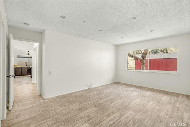 1824 Greenleaf Dr, West Covina, CA 91792 - spare room featuring a textured ceiling, light wood-style floors, and a smoke detector