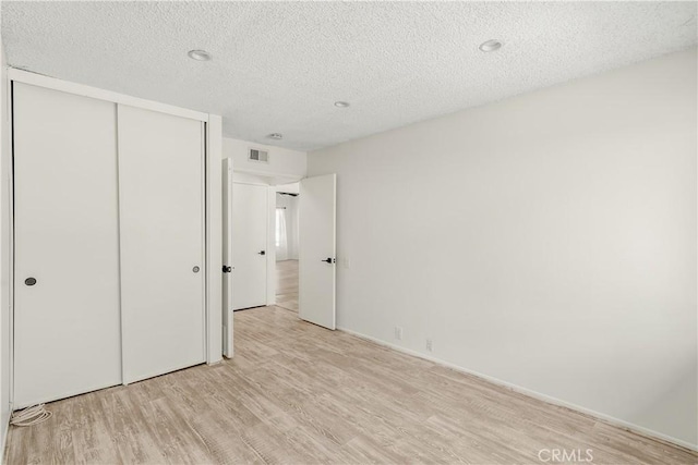 1824 Greenleaf Dr, West Covina, CA 91792 - unfurnished bedroom featuring light wood-type flooring, a textured ceiling, and a closet