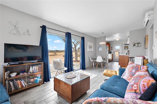 2654 Olympic Rd, Joshua Tree, CA 92252 - living area featuring a wall mounted AC and light wood-style flooring