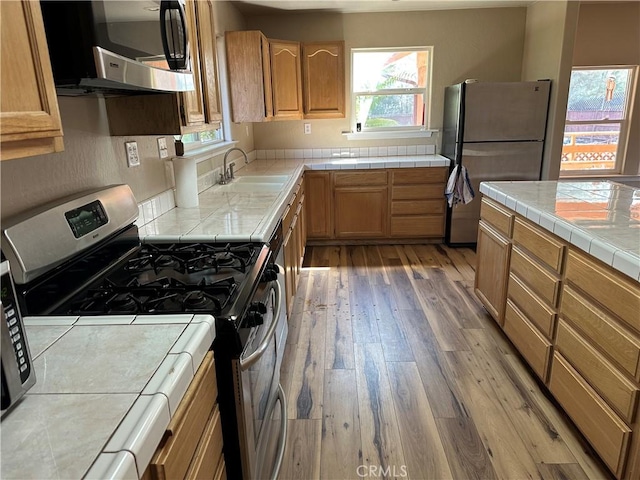 2240 Spring Valley Rd, Clearlake Oaks, CA 95423 - kitchen featuring stainless steel appliances, light wood-type flooring, and tile counters
