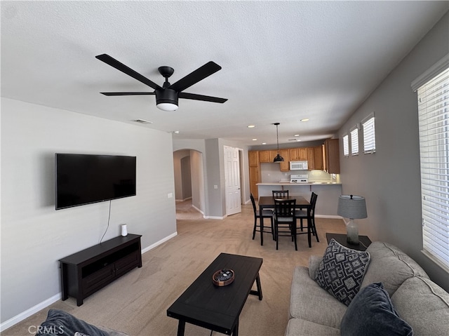 11115 Sun River Ct, Apple Valley, CA 92308 - living area with arched walkways, ceiling fan, light carpet, and recessed lighting