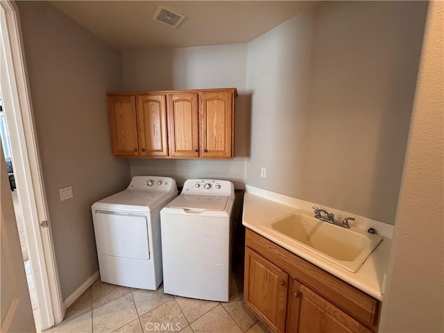 11115 Sun River Ct, Apple Valley, CA 92308 - laundry area featuring washing machine and dryer, cabinet space, and light tile patterned floors