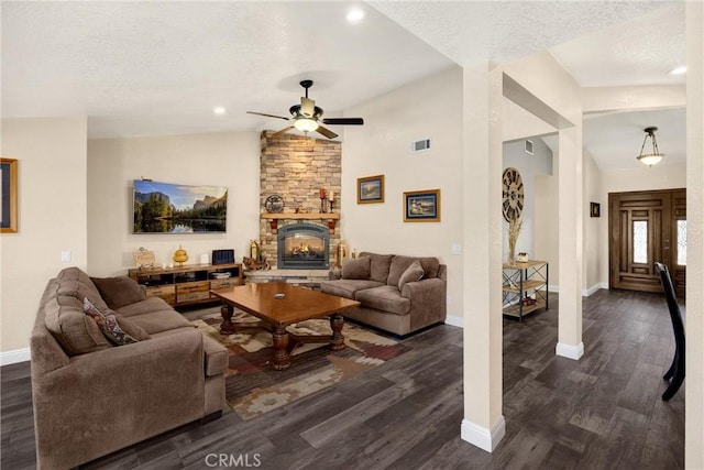 5829 Zapata Pl, Rancho Cucamonga, CA 91737 - living room featuring vaulted ceiling, a ceiling fan, dark wood-style flooring, a stone fireplace, and a textured ceiling