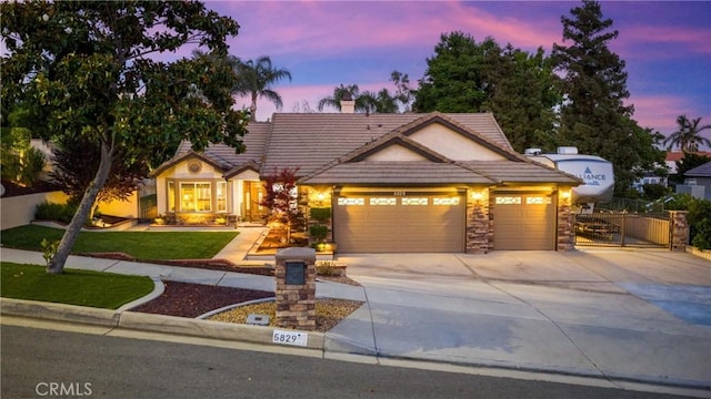 5829 Zapata Pl, Rancho Cucamonga, CA 91737 - view of front of home with an attached garage, driveway, a tile roof, a gate, and a front yard