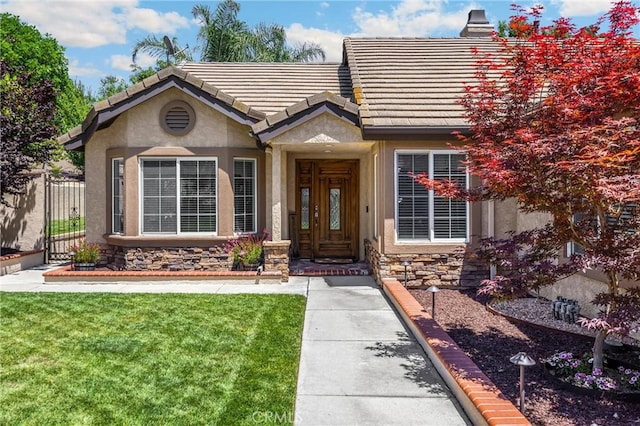 5829 Zapata Pl, Rancho Cucamonga, CA 91737 - property entrance with stucco siding, stone siding, and a tiled roof