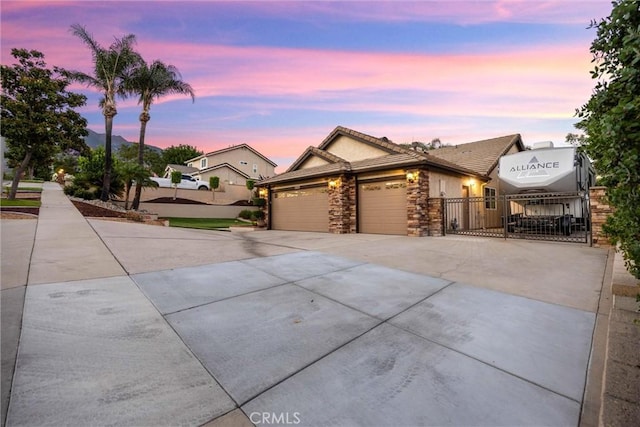5829 Zapata Pl, Rancho Cucamonga, CA 91737 - ranch-style house with a garage, driveway, stone siding, a gate, and a tiled roof
