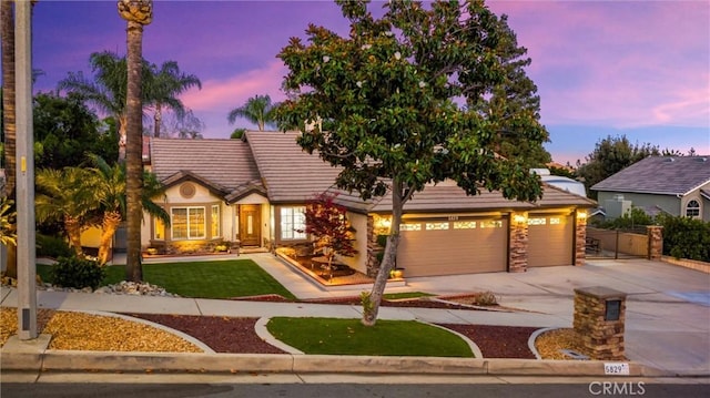 5829 Zapata Pl, Rancho Cucamonga, CA 91737 - view of front of property featuring driveway, stone siding, a tile roof, and a yard