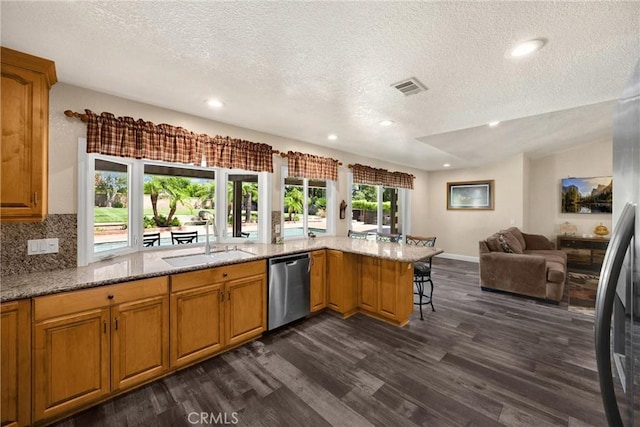 5829 Zapata Pl, Rancho Cucamonga, CA 91737 - kitchen with stainless steel dishwasher, dark wood-type flooring, a textured ceiling, open floor plan, and light stone countertops