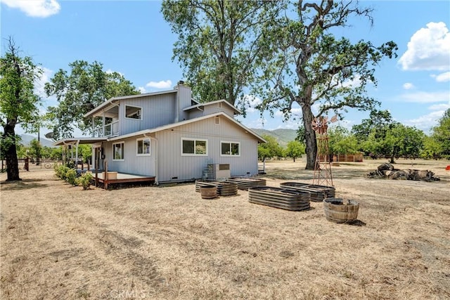 20511 Santa Barbara Ave, Middletown, CA 95461 - back of house featuring a vegetable garden, a balcony, a chimney, and a wooden deck