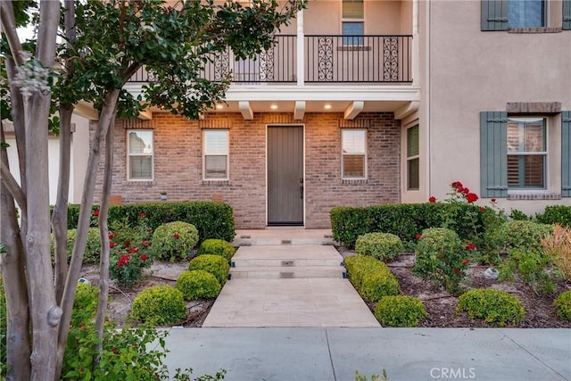111 Spoke, Irvine, CA 92618 - property entrance featuring a balcony, brick siding, and stucco siding