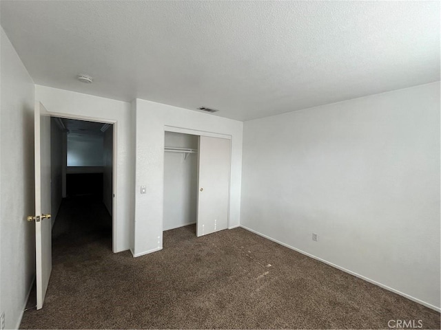 405 E Lurelane St, Rialto, CA 92376 - unfurnished bedroom with dark carpet, a closet, and a textured ceiling