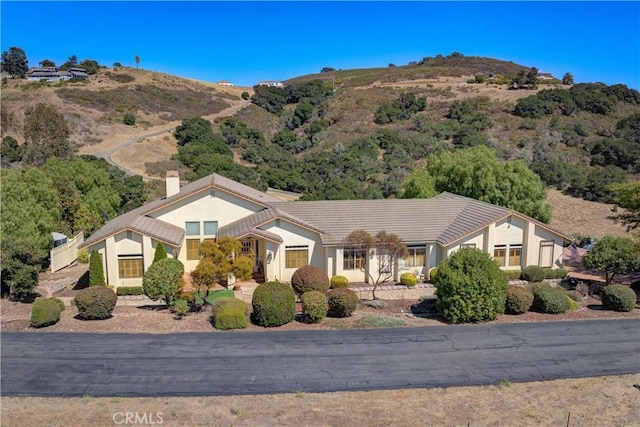 670 Highland Hills Rd, Nipomo, CA 93444 - view of front of house with a chimney, a mountain view, and stucco siding