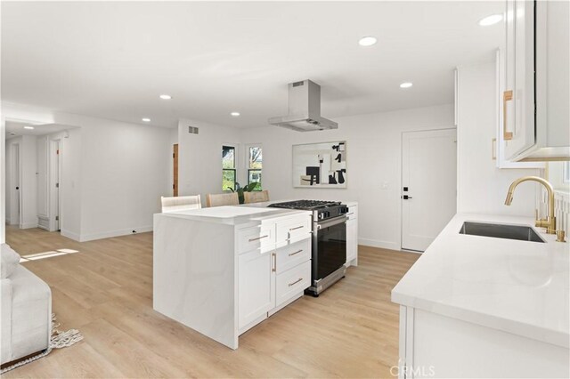 1825 W Carlton Pl, Santa Ana, CA 92704 - kitchen with stainless steel range with gas stovetop, range hood, white cabinets, recessed lighting, and light countertops