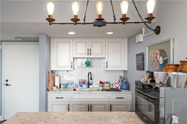 24055 W Paseo Del Lago Unit 962, Laguna Woods, CA 92637 - kitchen featuring stove, decorative backsplash, white cabinets, decorative light fixtures, and light stone counters