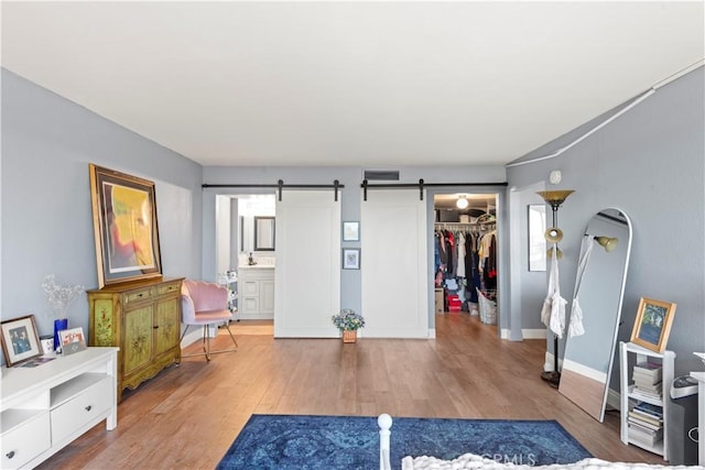 24055 W Paseo Del Lago Unit 962, Laguna Woods, CA 92637 - unfurnished bedroom with a spacious closet, wood finished floors, a barn door, and ensuite bath