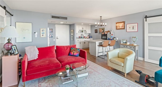 24055 W Paseo Del Lago Unit 962, Laguna Woods, CA 92637 - living room with a barn door, wood finished floors, and a chandelier