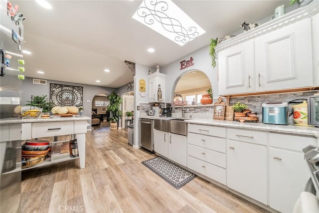 1181 W Westmont Ave, Hemet, CA 92543 - kitchen featuring arched walkways, stainless steel dishwasher, tasteful backsplash, light wood finished floors, and recessed lighting