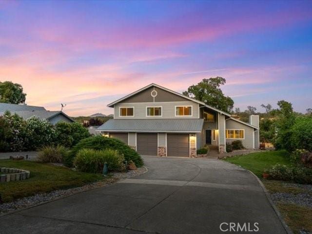 15540 China Rpds, Red Bluff, CA 96080 - view of front facade with an attached garage, asphalt driveway, a front lawn, and stone siding