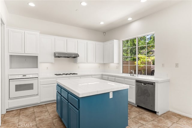 3959 Grandview Dr, Brea, CA 92823 - kitchen with white appliances, under cabinet range hood, blue cabinetry, white cabinets, and recessed lighting