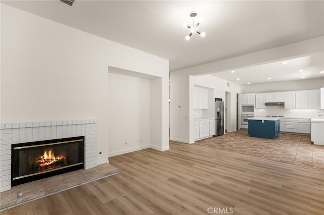 3959 Grandview Dr, Brea, CA 92823 - unfurnished living room with light wood-style flooring, a brick fireplace, and recessed lighting