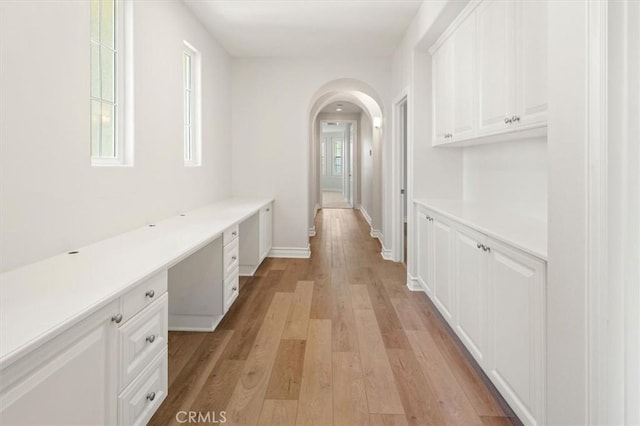 24711 Tiburon St, Valencia, CA 91355 - hall featuring arched walkways, light wood-style floors, and an office area