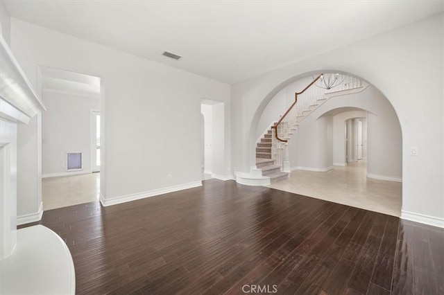 24711 Tiburon St, Valencia, CA 91355 - unfurnished living room with arched walkways, wood finished floors, and stairway